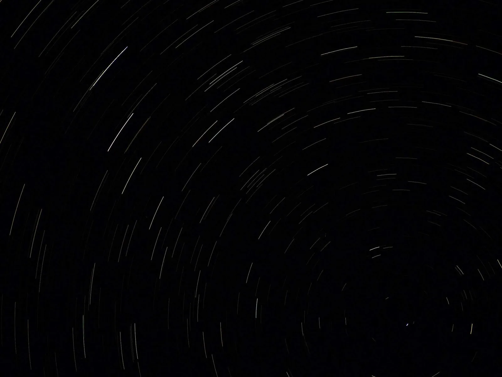 Star trails circling in a black night sky