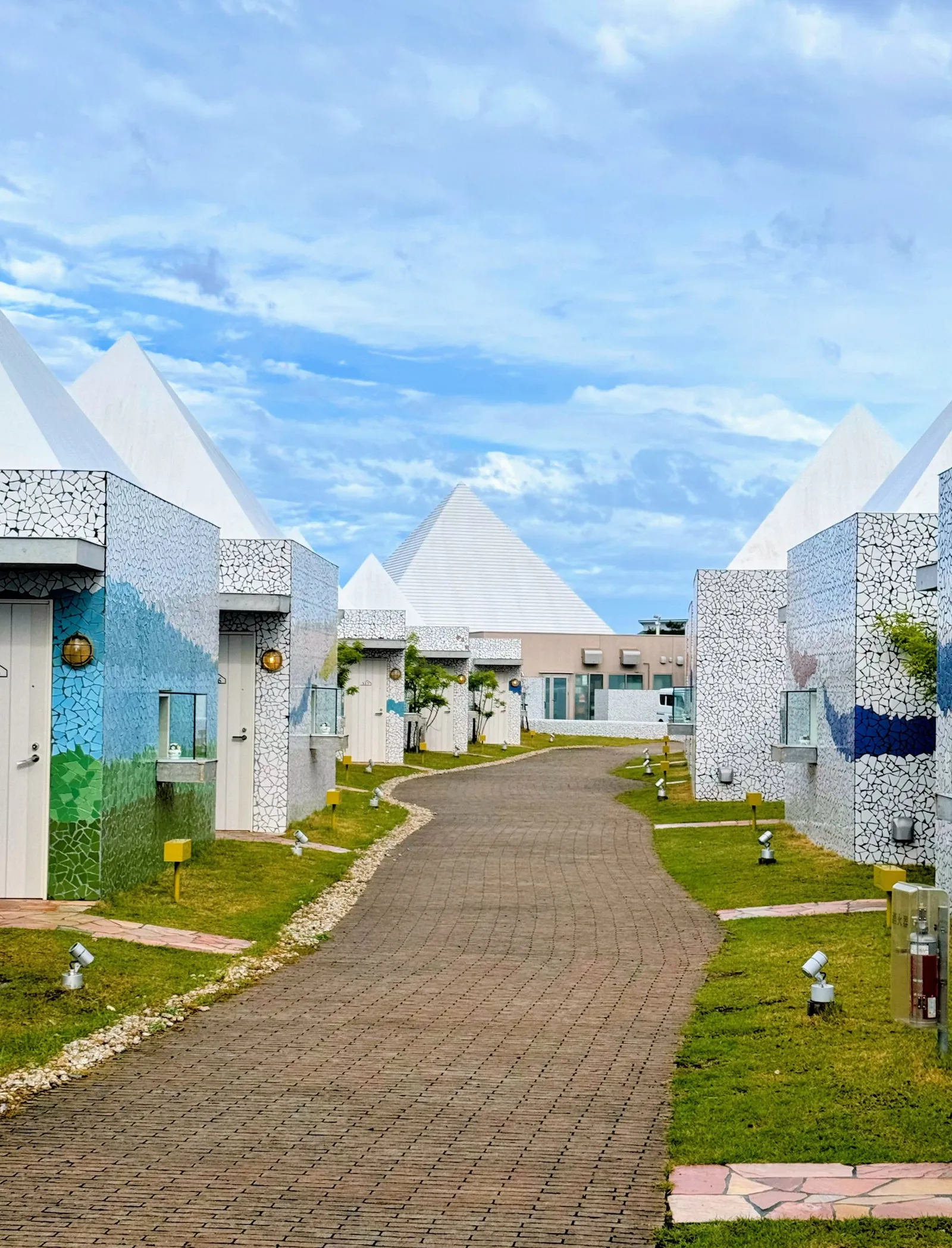 A path between rows of white pyramid-shaped cottages