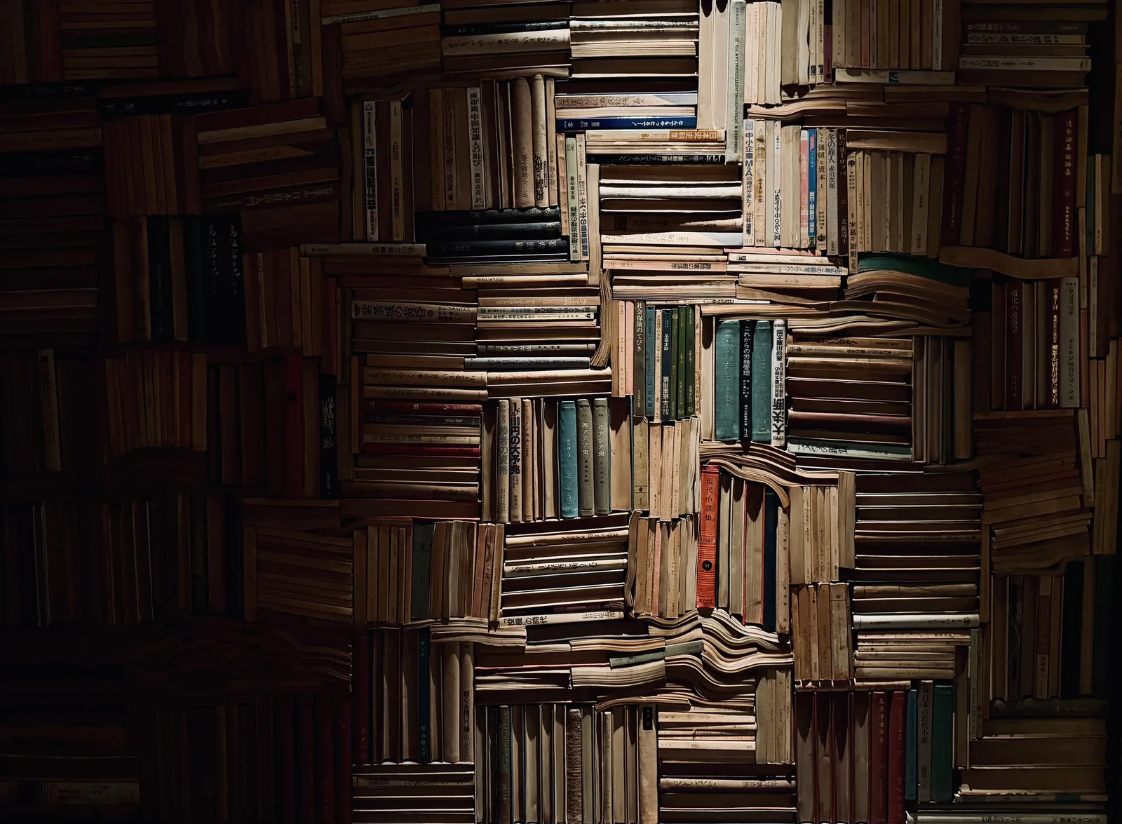 A dimly lit wall stacked full of old books